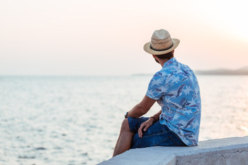 Young man enjoying sunset by the sea