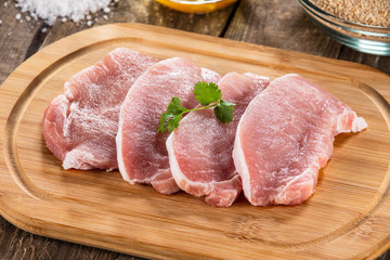 Raw pork chops on cutting board 