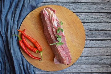Fresh raw meat and pepper on a wooden background.