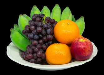 Naklejka na ściany i meble Fruit in a plate on a black background