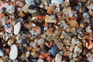 Texture of the small wet coastal sea pebbles and sand.