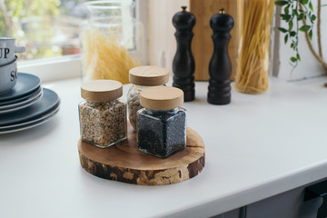 Organic glass spice jars on windowsill in kitchen, dishes, food