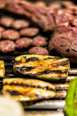 Grilled zucchini on the barbeque with steak and meatballs