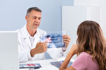 Obraz premium Doctor Showing Dental X-ray In Clinic