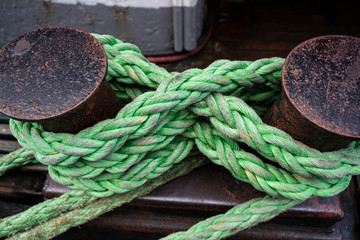 Green twisted marine rope wraped around metal poles