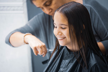 Madre cortando el cabello a su hija en casa