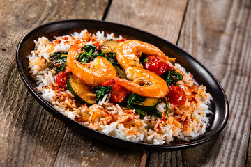 Shrimps with white rice and vegetables on wooden table