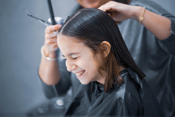 Madre cortando el cabello a su hija en casa