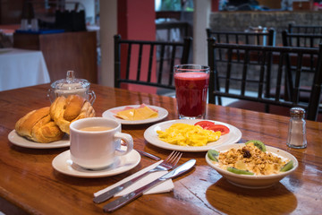 Breakfast characteristic of a hotel in the Amazon of Ecuador. Coffee, natural juice, fruits, scrambled eggs, bread, salt and sugar are observed