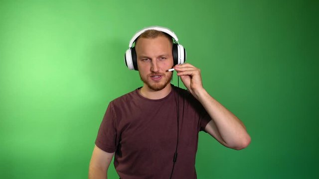 the bearded man sets up the microphone in the headphones and starts the game on the consol