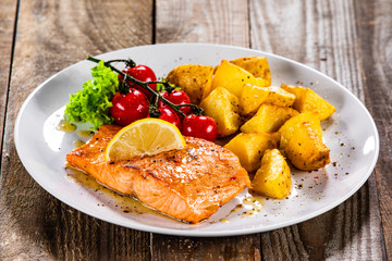 Fried salmon with baked potatoes and vegetables