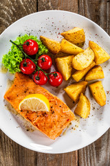 Fried salmon with baked potatoes and vegetables