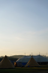 Tent on a field at dusk with blue sky
