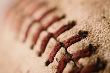 Macro baseball images shows red seams and texture of sports ball.