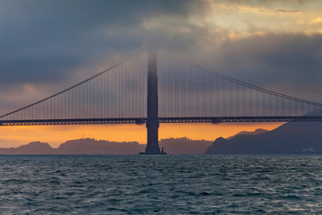 Fototapeta na wymiar Enchanting foggy sunset over Golden Gate bridge in San Francisco