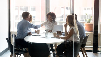 Smiling diverse employees handshake greeting at office meeting