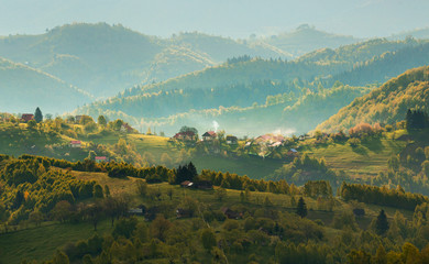 Transylvania rural landscape with a Romanian traditional village on the hills - Morning Mist