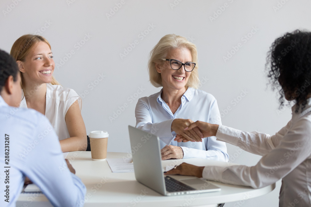 Canvas Prints Smiling diverse businesswomen handshake closing deal at meeting