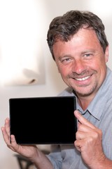 smiling man handsome is holding tablet with a blank screen black indoor