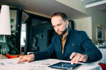 Man Working in Office and Analyzing Some Statistical Calculation Reports.