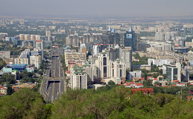 Fototapeta na wymiar Almaty, Kazakhstan - August 24, 2019: View over the skyline of Almaty with slight smog clouds over the city.