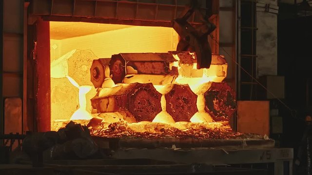 Work tick-borne crane at an engineering plant. The crane lifts the hot steel billets to move into the forging press.