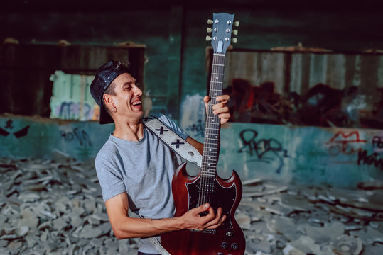 Musician playing electric guitar in abandoned place