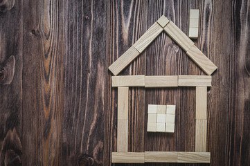 house made of wooden blocks on a wooden background, top view, tinted and vignetting