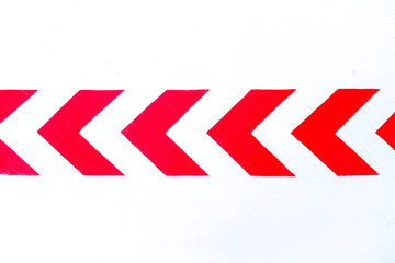 Bold red arrows reflective paint on white reflective background, road markings, flash gun artificial light.