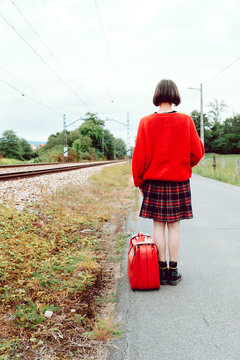 Woman looking at approaching modern train on railroad
