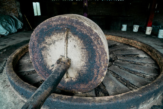 Empty grungy large mill press at traditional distillery in daylight