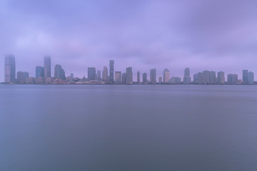 Jersey city from Hudson river on a foggy morning