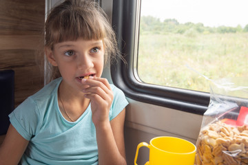 Fototapeta premium Girl eats cookies in a train
