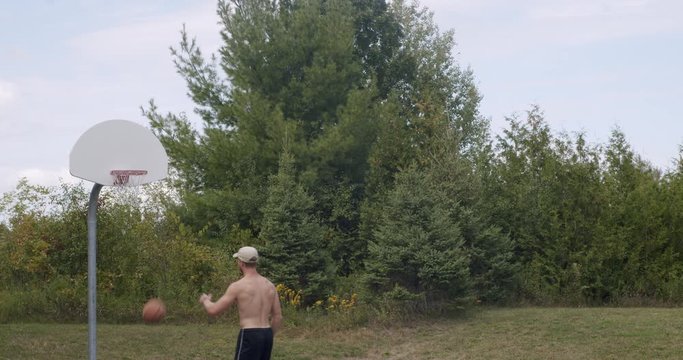 Man Playing Basketball on Outdoor Court Shooting