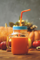 Pumpkins juice in bottles with pumpkins. Autumn harvest of pumpkins on a table. Smoothies.