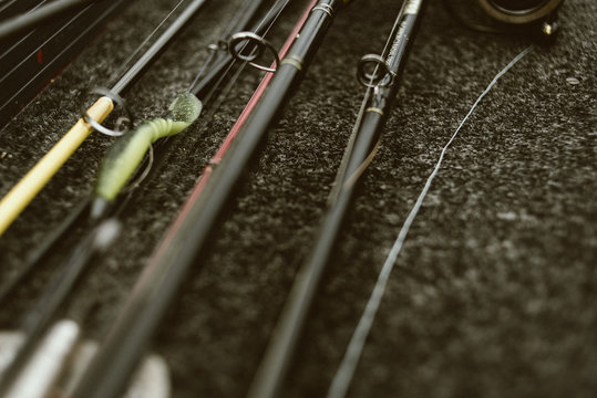 Closeup from above of fishing equipment with fishing rods on ground ready for fishing