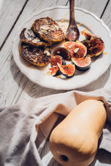 Pumpkin pancakes with figs on white wooden table