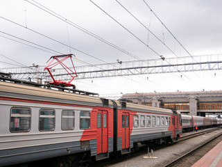 Obraz premium The train at the railway station on a cloudy day. Electric train.