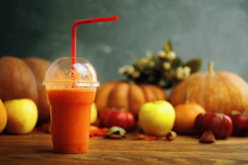 Pumpkins juice in bottles with pumpkins. Healthy pumpkin smoothie in glasses on rustic background.