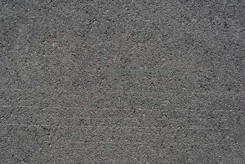 Smooth asphalt road. Tarmac dark grey grainy road background. Top view grunge rough surface
