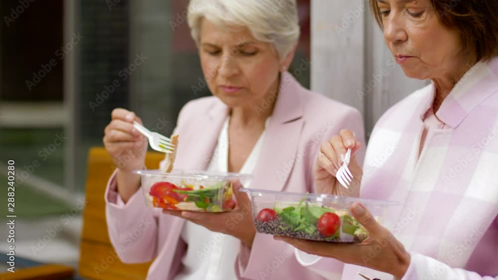 Canvas Prints old age, leisure and food concept - senior women or friends eating takeaway salad on city street