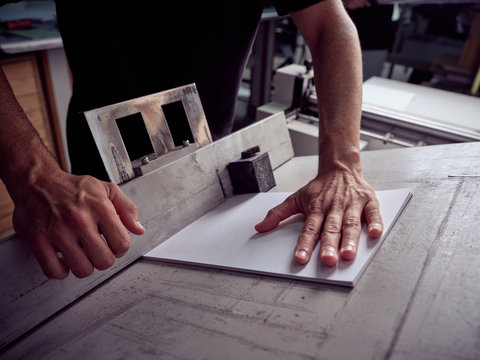 Unrecognizable employee using professional tools for book making