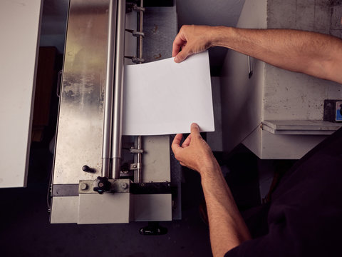 Unrecognizable employee using professional tools for book making