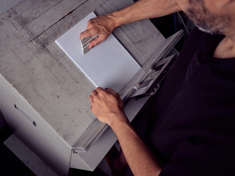 Faceless employee working with paper in printing house