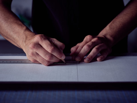 Bookbinder making markup with pencil on page