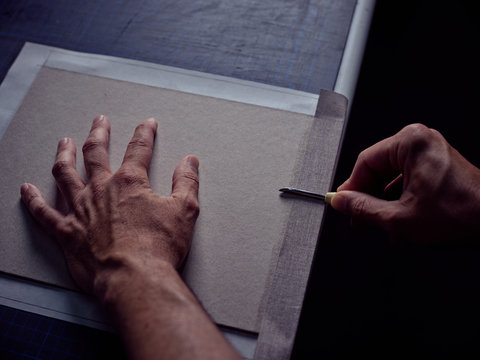 Bookbinder imposing fabric on cover for book