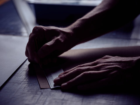 Bookbinder making markup with pencil on page