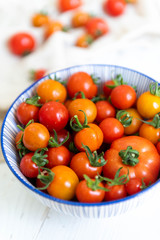 Fototapeta na wymiar Freshly Picked Various Tomatoes in Blue Striped Bowl