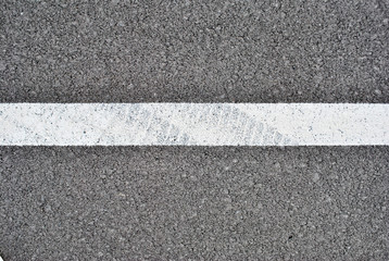 Fototapeta premium Asphalt texture with white line and tire marks . Top view