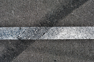 Fototapeta premium Asphalt texture with white line and tire marks . Top view